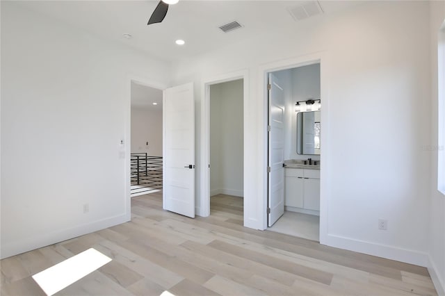 unfurnished bedroom featuring ensuite bathroom, sink, ceiling fan, and light hardwood / wood-style floors