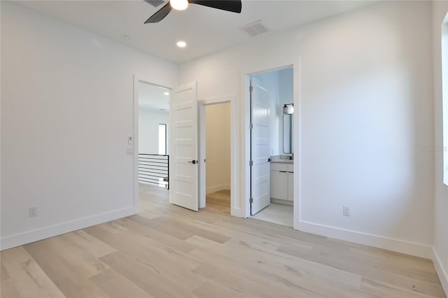 unfurnished bedroom with connected bathroom, ceiling fan, and light wood-type flooring