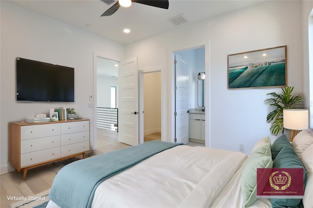 bedroom featuring ensuite bathroom, ceiling fan, and light wood-type flooring