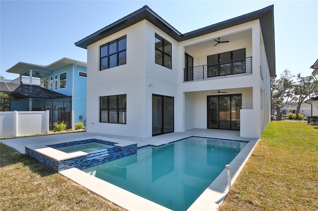 back of house featuring a patio area, a balcony, a yard, a pool with hot tub, and ceiling fan