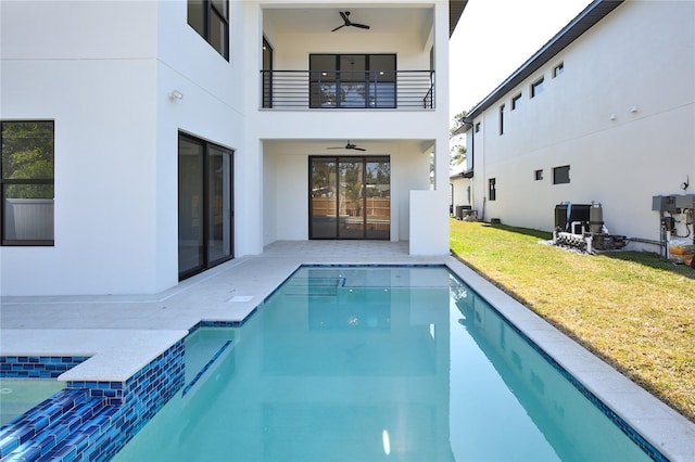 exterior space with a patio area, ceiling fan, a balcony, and a lawn