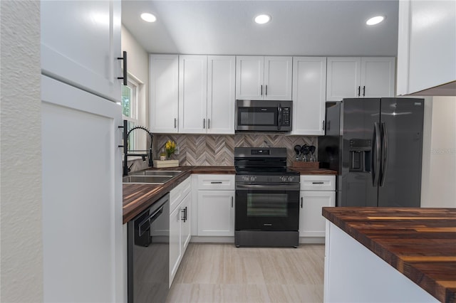 kitchen featuring sink, wooden counters, stainless steel appliances, tasteful backsplash, and white cabinets