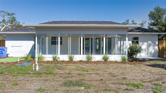 back of property with a sunroom