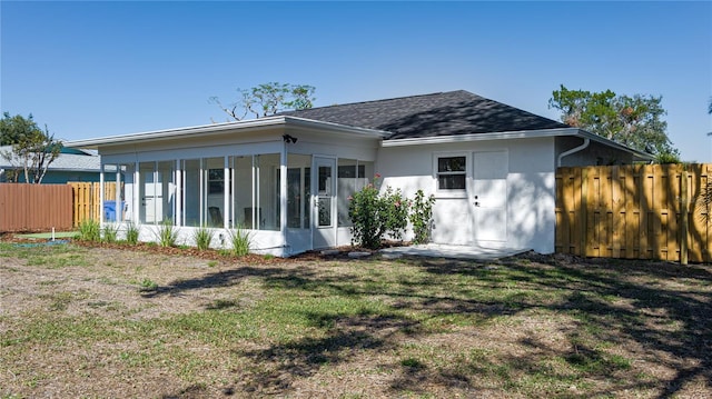 back of house featuring a sunroom and a yard