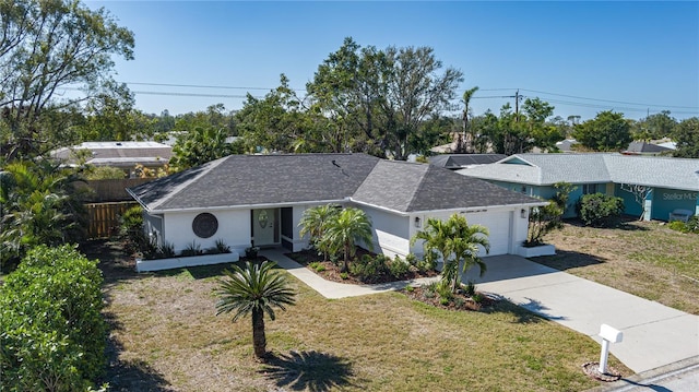 ranch-style house featuring concrete driveway, an attached garage, fence, a front lawn, and stucco siding