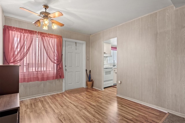 spare room with ornamental molding, a wealth of natural light, light hardwood / wood-style floors, and ceiling fan