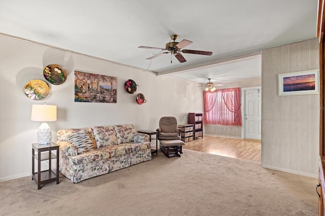 living room with beamed ceiling, ceiling fan, and carpet floors