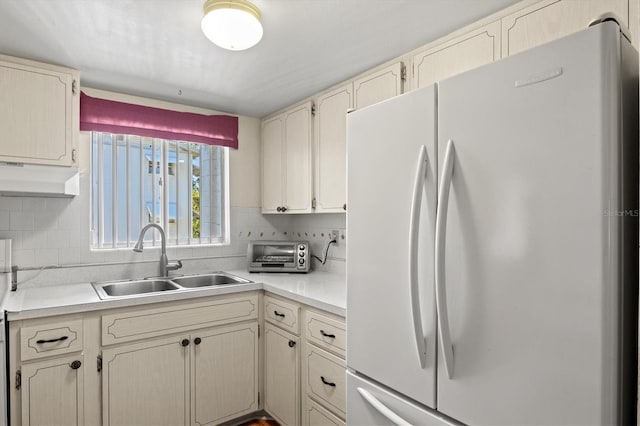 kitchen with white fridge, sink, and decorative backsplash