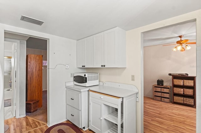 kitchen featuring white cabinetry, ceiling fan, and light wood-type flooring