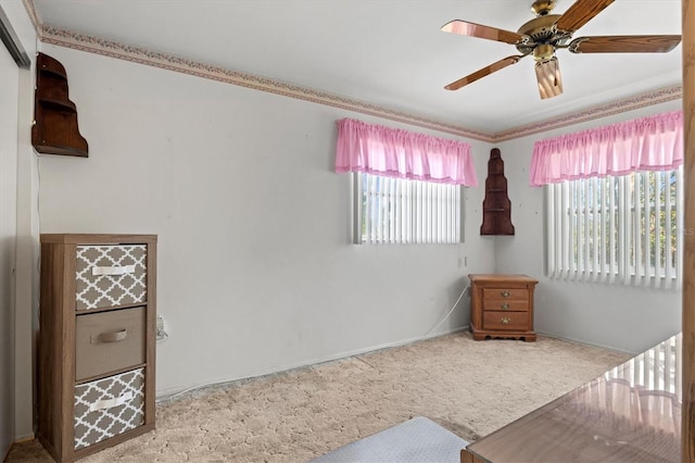 carpeted bedroom featuring multiple windows and ceiling fan