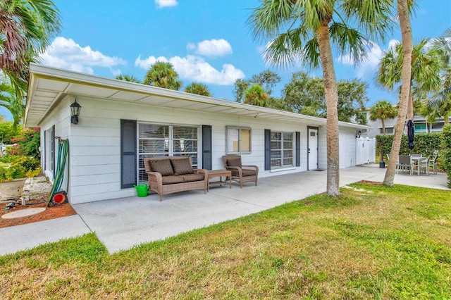 rear view of house featuring a yard, an outdoor hangout area, and a patio