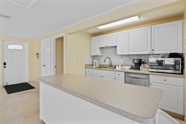 kitchen with stainless steel appliances, white cabinetry, sink, and tasteful backsplash