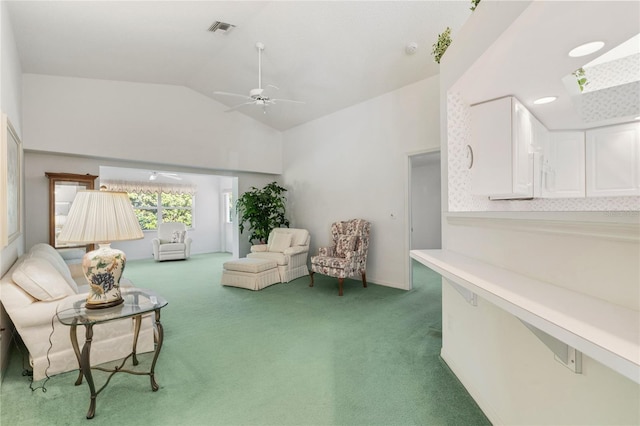 sitting room with lofted ceiling with skylight, carpet, and ceiling fan