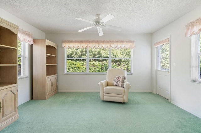 unfurnished room featuring ceiling fan, light colored carpet, and a textured ceiling
