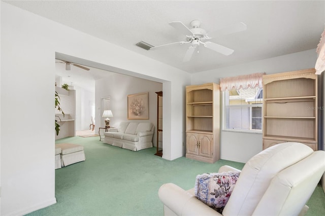 living area featuring a textured ceiling, ceiling fan, and carpet flooring