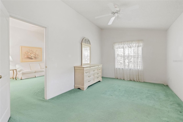 carpeted empty room featuring vaulted ceiling and ceiling fan