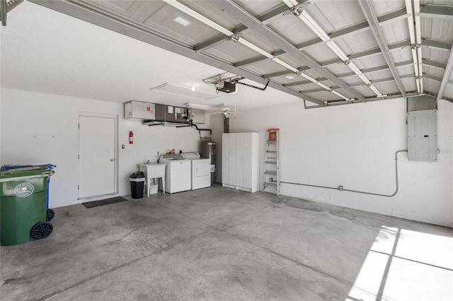 garage featuring washing machine and clothes dryer, a garage door opener, electric panel, and sink