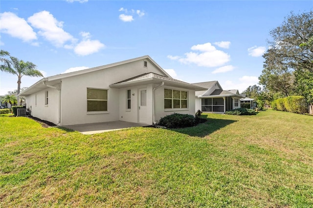 rear view of house with a patio area, central AC, and a lawn