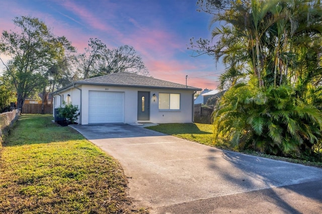 view of front of property featuring a garage and a lawn