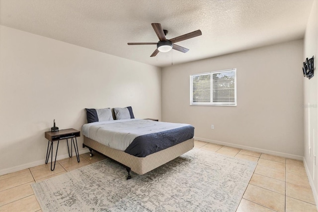 bedroom with ceiling fan, a textured ceiling, and light tile patterned floors