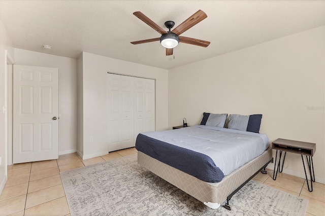 bedroom with ceiling fan, a closet, and light tile patterned floors