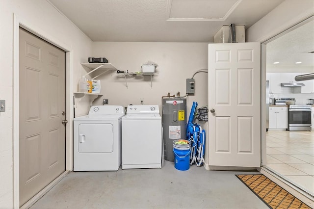 washroom featuring washer and clothes dryer, water heater, and a textured ceiling