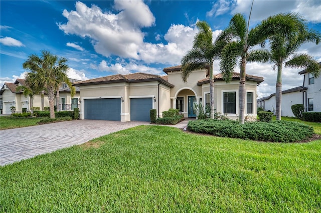 mediterranean / spanish home with a garage and a front lawn