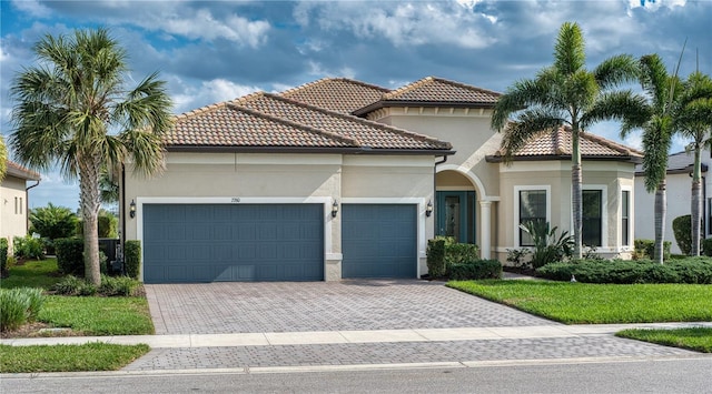 mediterranean / spanish-style house featuring a garage and a front yard