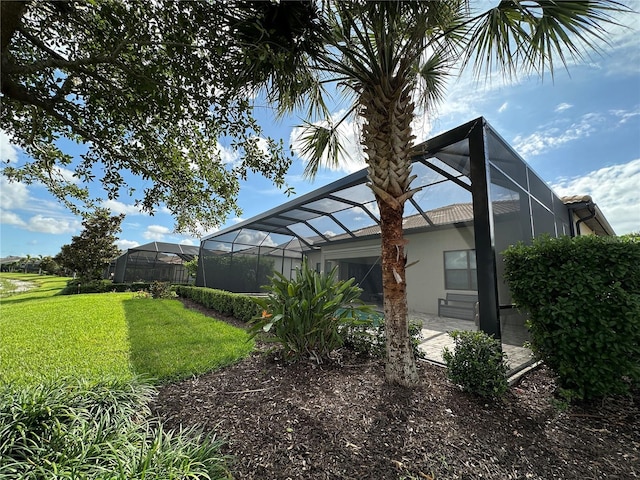 7760 Grande Shores Dr, Sarasota, FL 34240 - view of side of home with a yard and glass enclosure