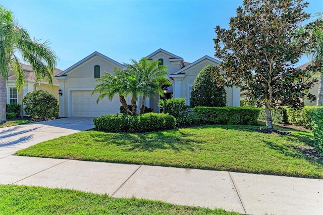 view of front of house with a garage, concrete driveway, a front yard, and stucco siding