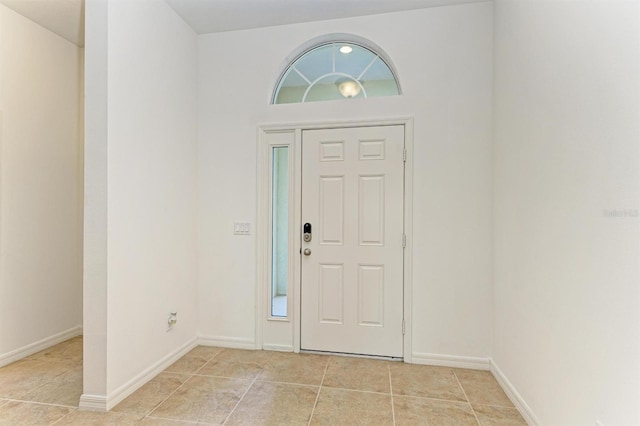 foyer entrance with light tile patterned floors and baseboards