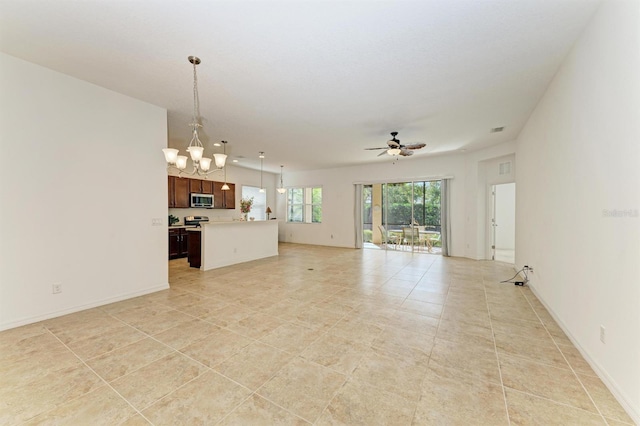 unfurnished living room with visible vents, light tile patterned floors, ceiling fan with notable chandelier, and baseboards