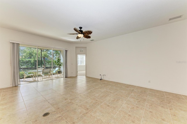 spare room with baseboards, visible vents, and ceiling fan