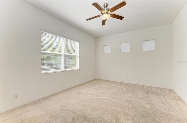 empty room with light carpet, baseboards, and ceiling fan