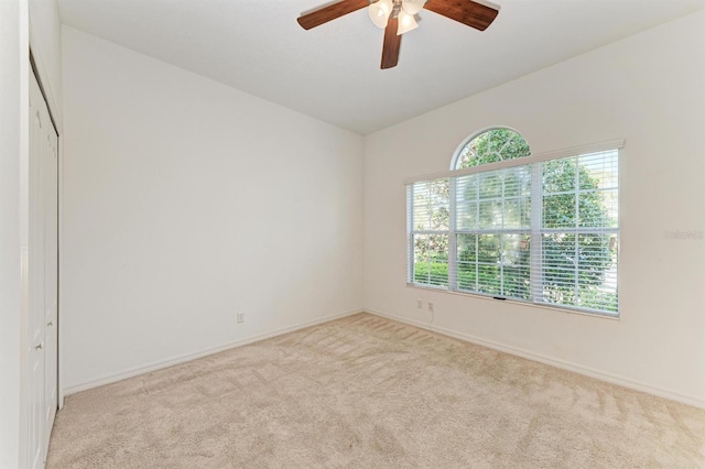 unfurnished room featuring a ceiling fan, carpet, and baseboards