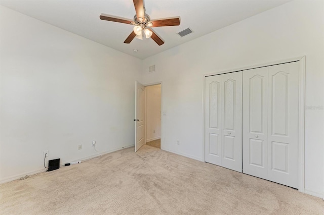 unfurnished bedroom featuring carpet, visible vents, a closet, and ceiling fan