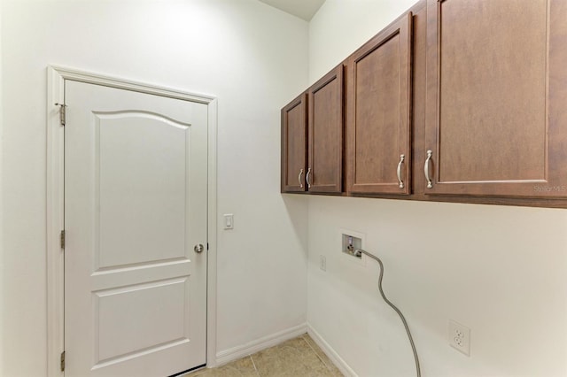 laundry area with washer hookup, light tile patterned floors, cabinet space, and baseboards