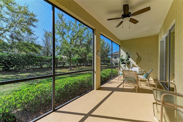 unfurnished sunroom with ceiling fan