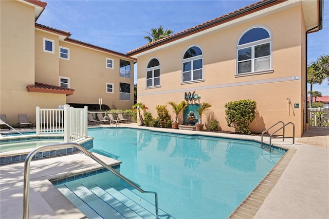 view of swimming pool featuring a hot tub