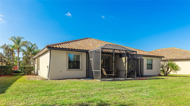 back of house featuring a yard and a lanai