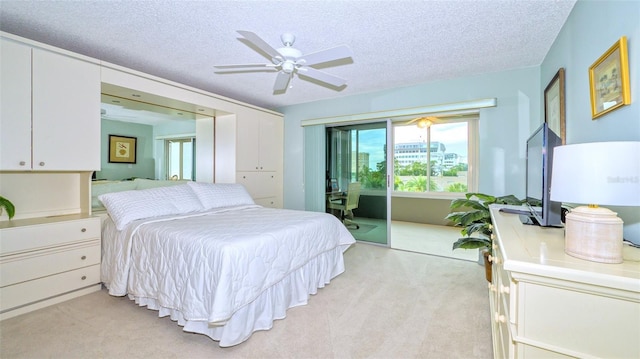 bedroom with ceiling fan, light colored carpet, access to exterior, and a textured ceiling