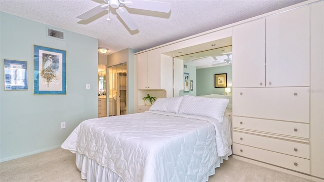 bedroom featuring ceiling fan, light colored carpet, and a textured ceiling