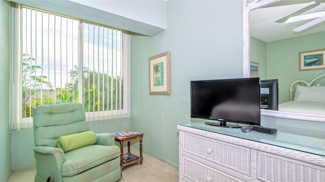 sitting room featuring ceiling fan and light colored carpet