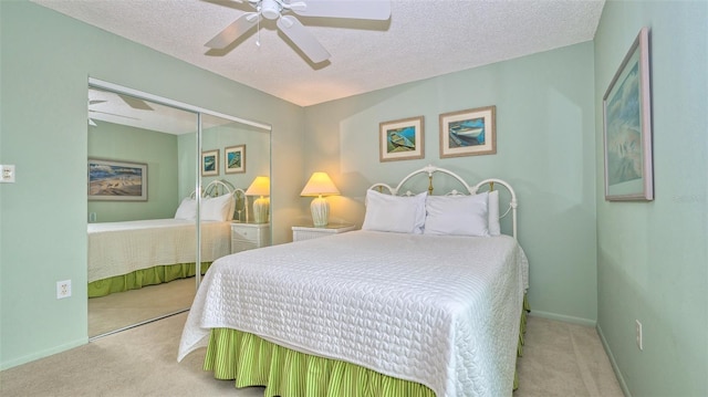 bedroom with a closet, light carpet, and a textured ceiling