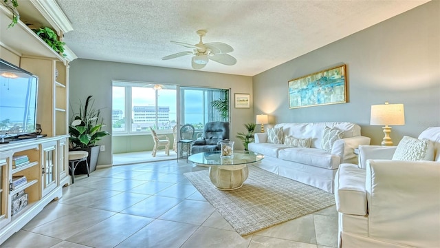 living room with light tile patterned floors, a textured ceiling, and ceiling fan