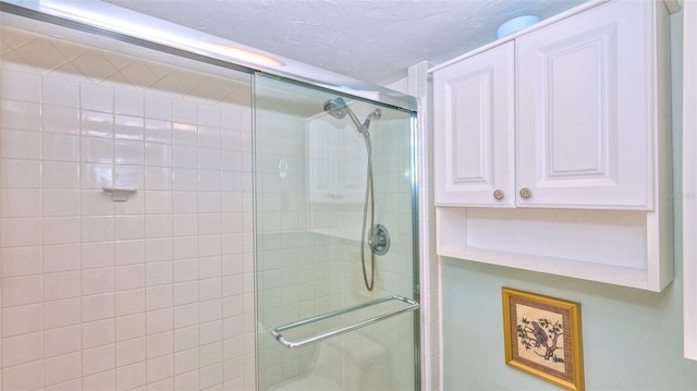 bathroom featuring an enclosed shower and a textured ceiling