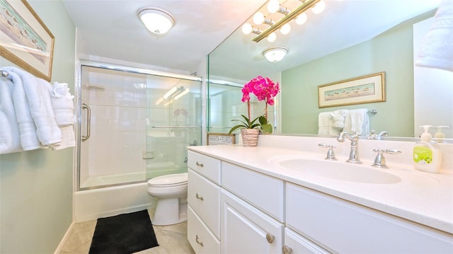 full bathroom featuring vanity, combined bath / shower with glass door, tile patterned floors, and toilet