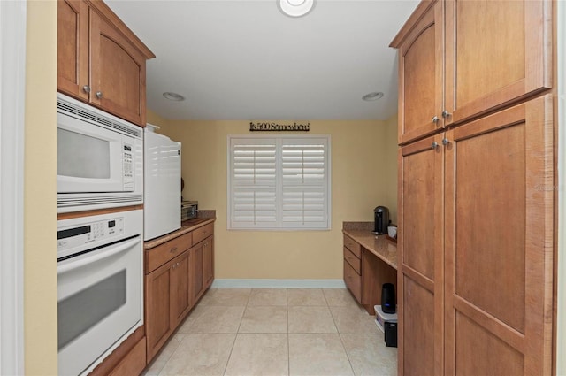 kitchen with light tile patterned flooring and white appliances