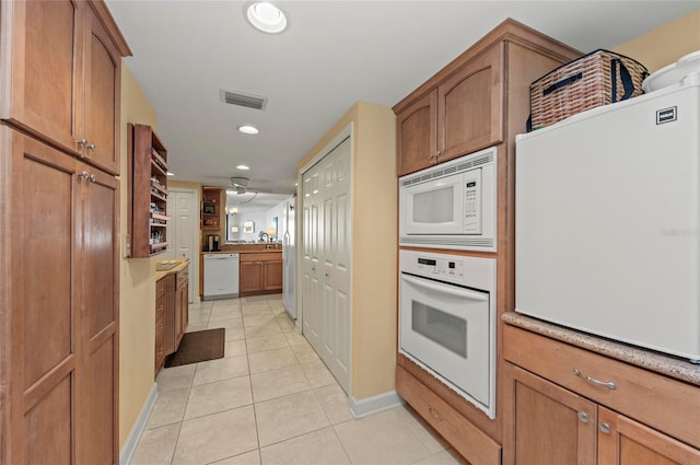 kitchen featuring light tile patterned flooring, sink, and white appliances