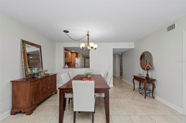 dining area featuring light tile patterned floors and a notable chandelier